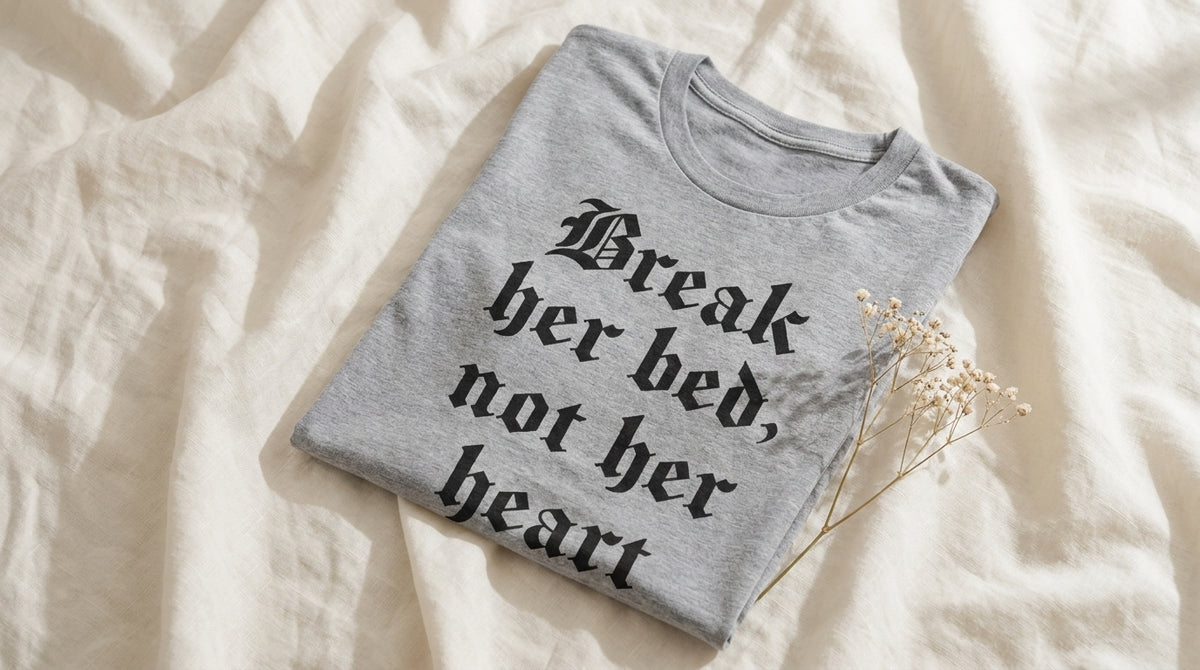Break Her Bed Not Her Heart athletic heather graphic tee folded on rumpled ivory linen with baby's breath – Peachy Sunday Journal UGC hero