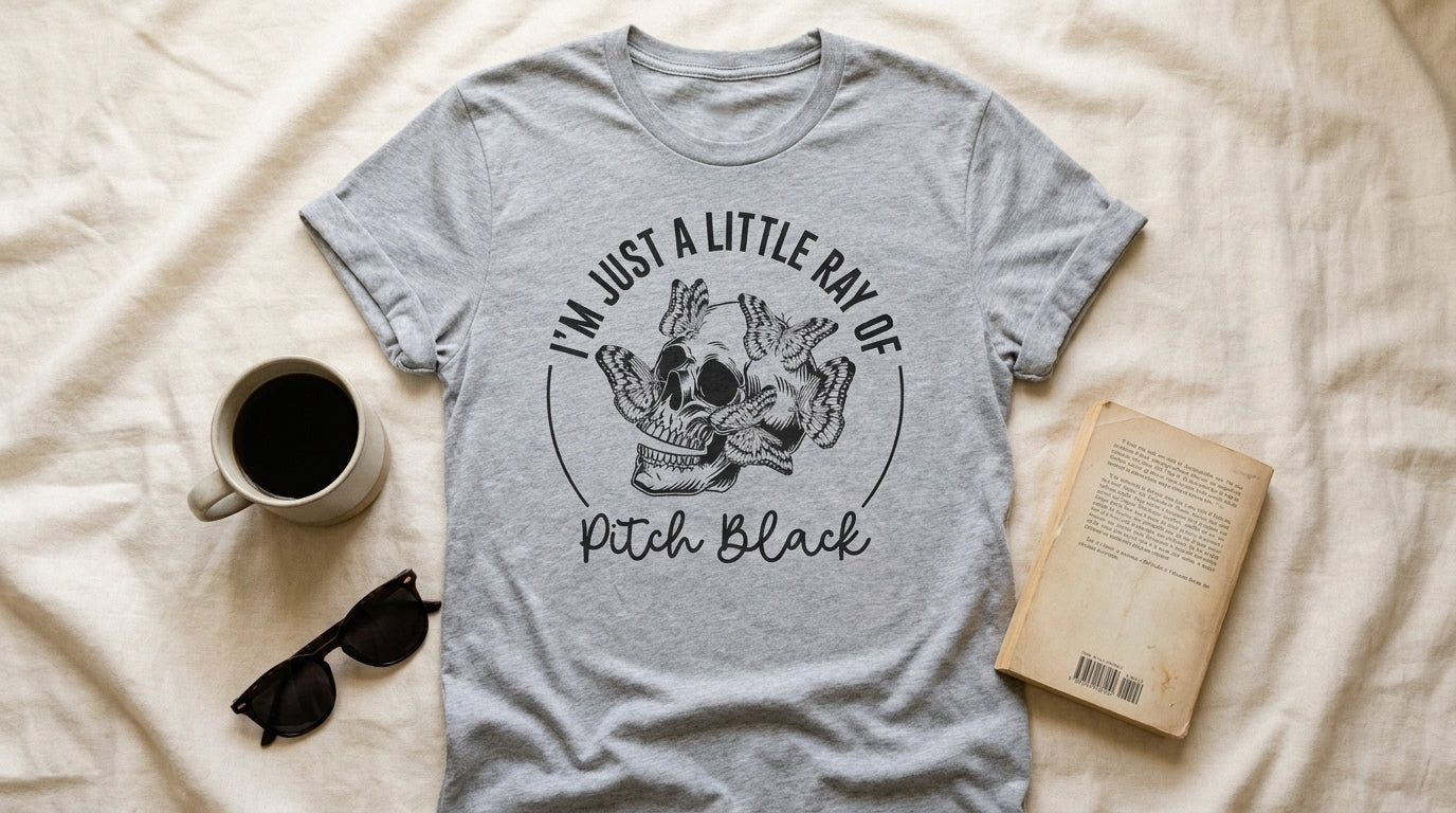 Athletic heather I'm Just A Little Ray Of Pitch Black tee flat-laid on cream linen with coffee and sunglasses – Peachy Sunday UGC flat lay
