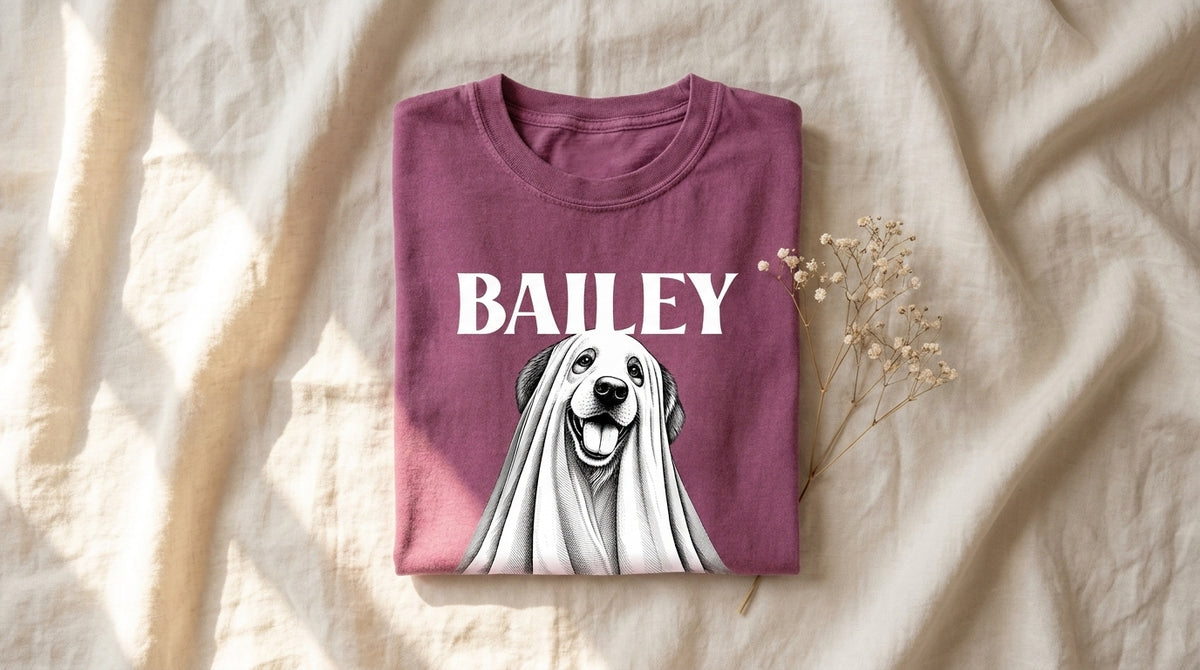 Personalized Halloween Ghost Dog Graphic Top in Berry folded on rumpled ivory linen with baby's breath sprig