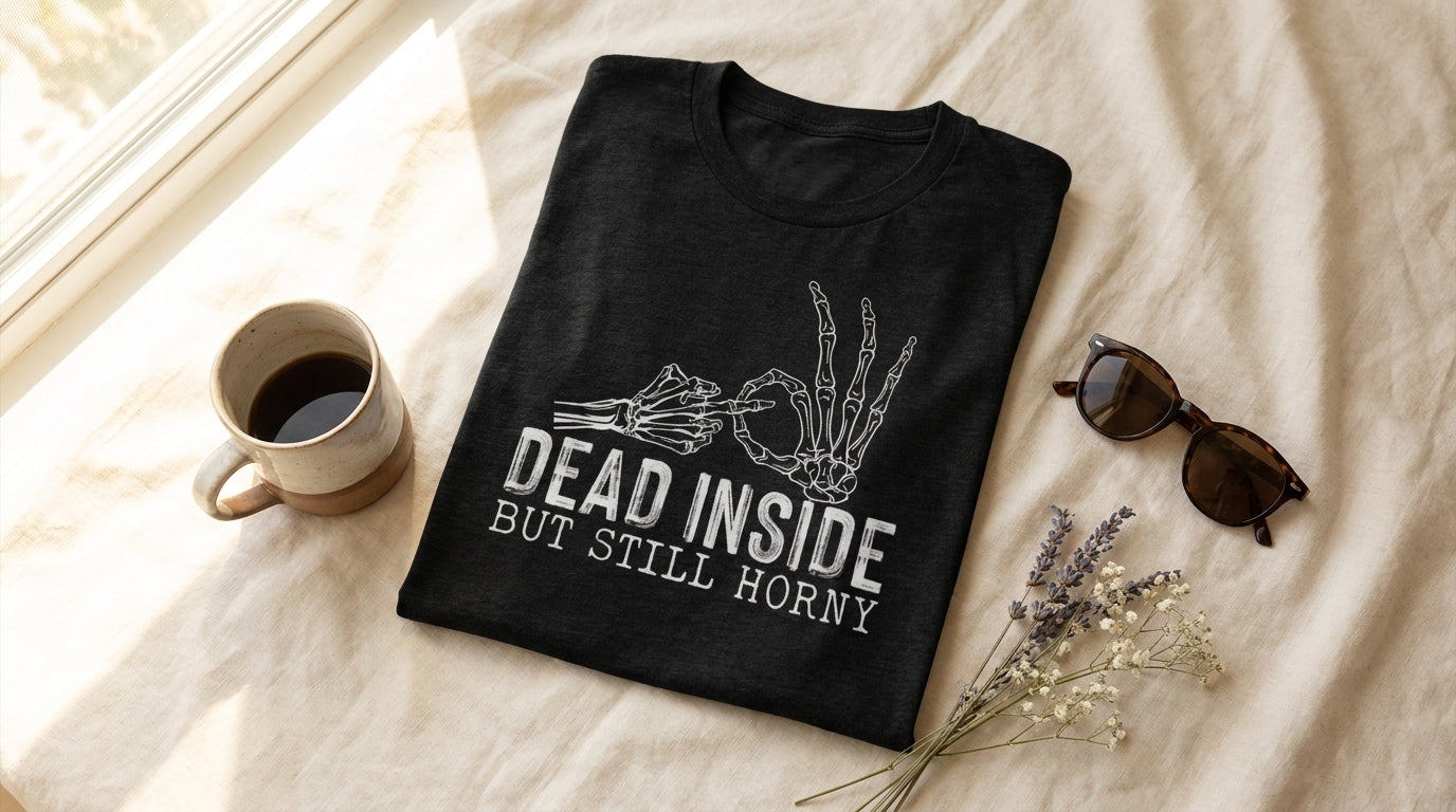 Dead Inside But Still Horny black heather graphic tee UGC flat lay on cream linen with coffee mug and sunglasses – Peachy Sunday funny sarcastic shirt