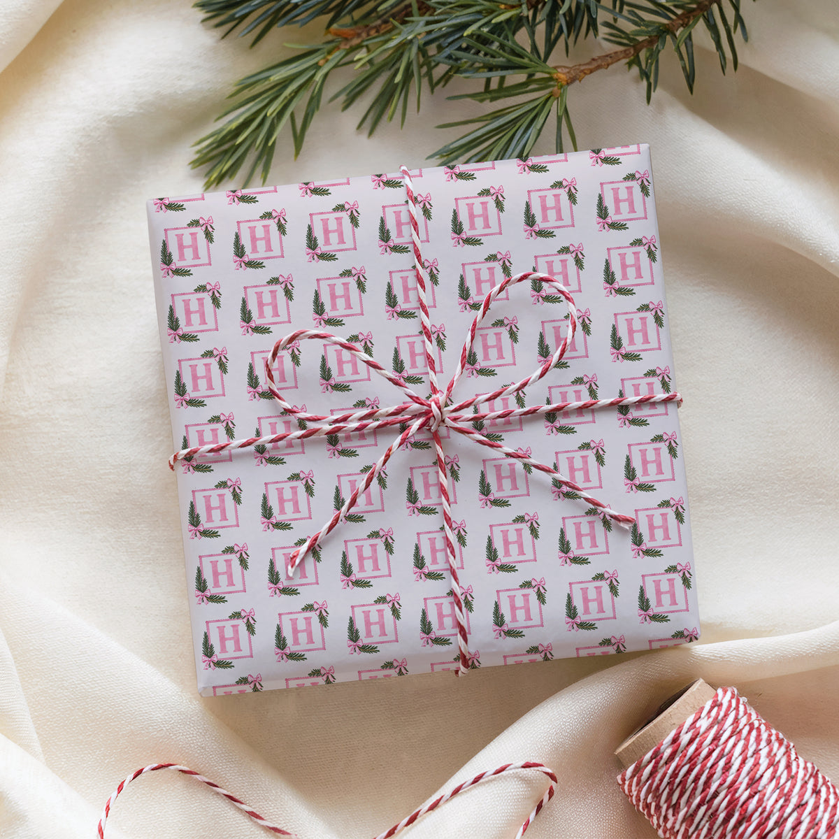 Custom initial holiday present wrapped in pink watercolor paper