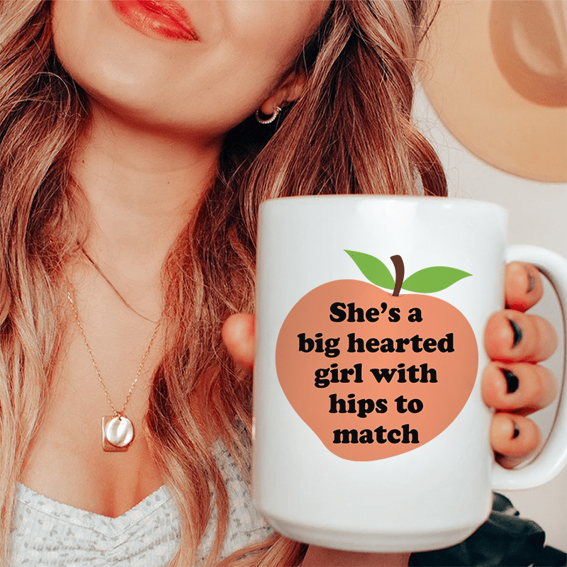 She's A Big Hearted Girl With Hips to Match Ceramic Mug 15 oz White / One Size CustomCat Drinkware T-Shirt